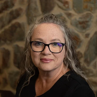 Stephanie Smiling In Front Of Cobble Wall