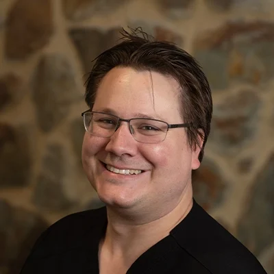 Dustin Smiling In Front Of Cobble Wall