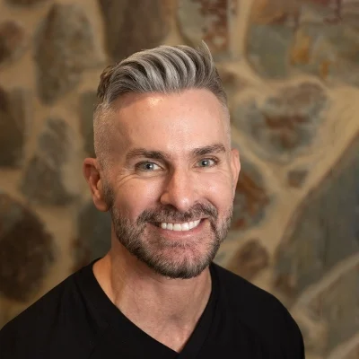 Joe Smiling In Front Of Cobble Wall